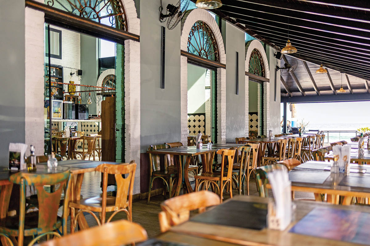 Ô Zê Gastronomia se destaca no cenário gastronômico de Macaé. Uma fachada elegante, marcada por portas em arco, em uma estética vintage agraciada pela vista para a Praia dos Cavaleiros
