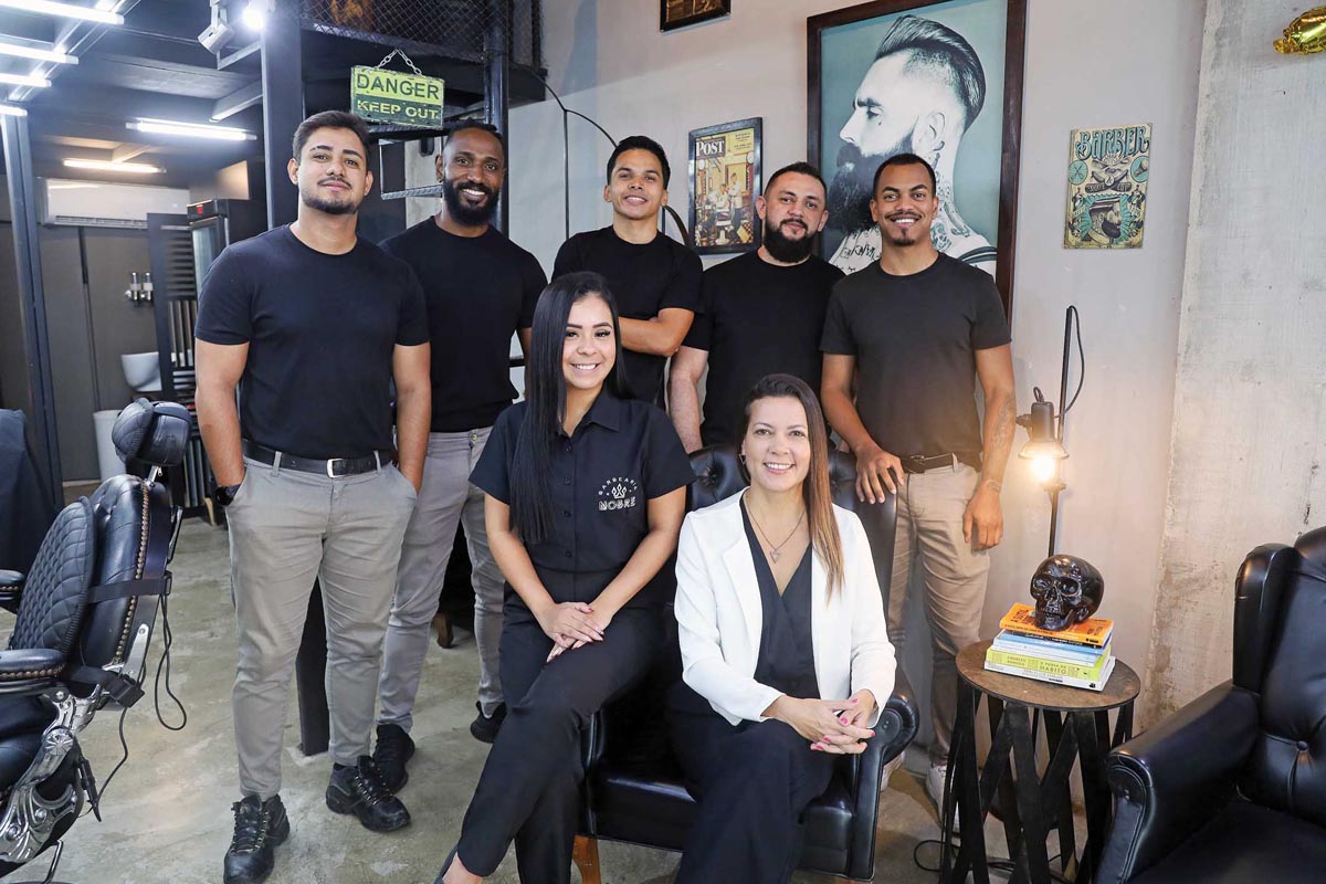 Andréia Nobre, de branco, com sua equipe na Barbearia Nobre, que completou 9 anos de sucesso. Em pé, da esquerda para a direita: Eduardo, Alan, Darlan, Dinho e Erick. Ao lado de Andréia, Layza. (Foto Alle Tavares)